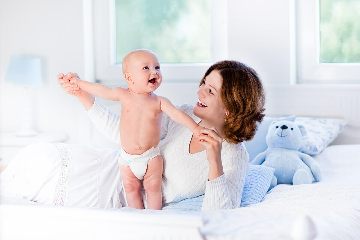 Mother and baby on white bed