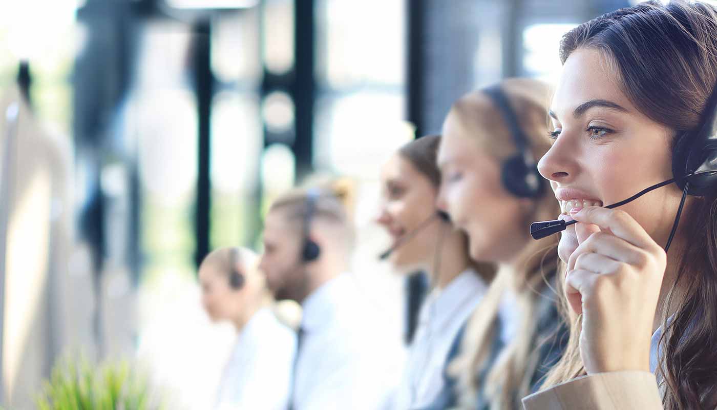 a-Female-customer-support-operator-from-Gomlaza-Store-wearing-the-headset-and-smiling-with-colleague's-background